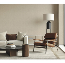 Woonkamer met bank, fauteuil, salontafel en staande lamp in een helder design.