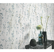 Wand met bloemenbehangpatroon en decoratieve vazen op een tafel