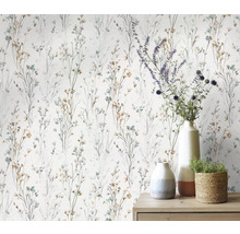 Behang met fijn bloemmotief en diverse decoratieve objecten op een commode.