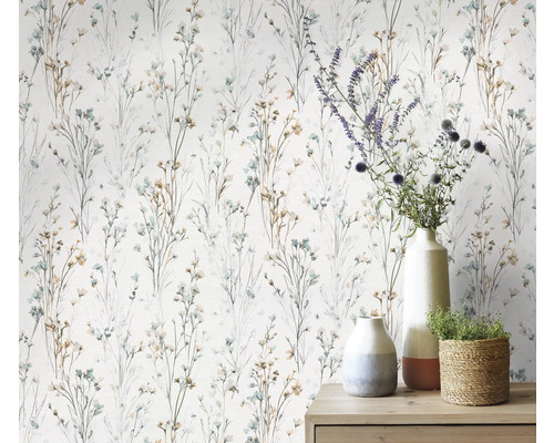 Behang met fijn bloemmotief en diverse decoratieve objecten op een commode.