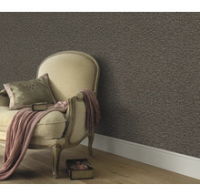 Woonkamer scène met fauteuil, kussen, deken en patroonbehang