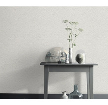 Scene met een wit behang met steenmotief en een bijzettafel met decoratieve objecten