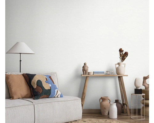 Woonkamer met bank, staande lamp en decoratie