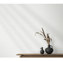 Twee donkere vazen met plantendecoratie op een houten tafel