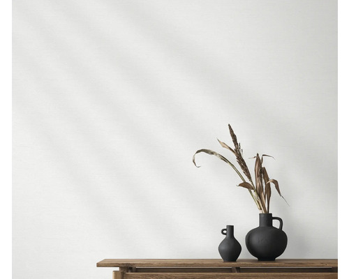 Twee donkere vazen met plantendecoratie op een houten tafel