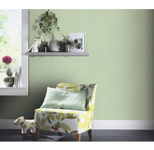 Decoratieve kamer met groen vliesbehang, fauteuil met plantenpatroon en raam met decoratie
