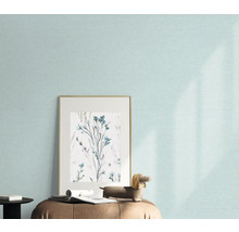 Close-up van een muur met licht behang, een ingelijste afbeelding met bloemenmotief en een decoratief figuur