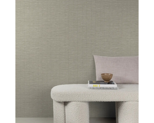 Gedetailleerde opname van een beige structuurbehang met bank, kussen en decoratie