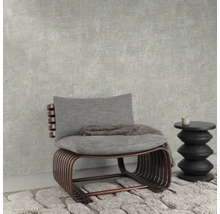 Zitmeubel met kussen en bijzettafel op tapijt voor een muur