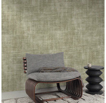 Close-up van een muur met textielbehang, een stoel en een kleine tafel