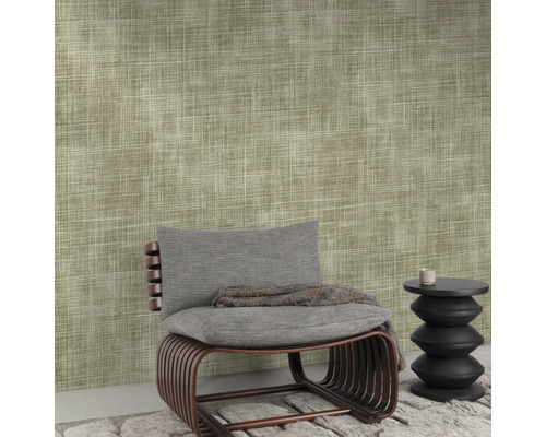 Close-up van een muur met textielbehang, een stoel en een kleine tafel