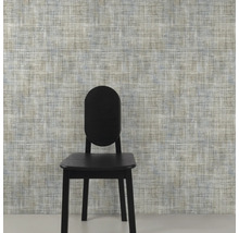 Close-up van een muur met textielbehang en een stoel