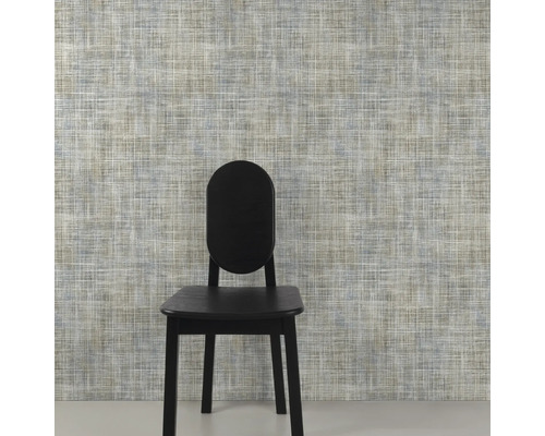 Close-up van een muur met textielbehang en een stoel