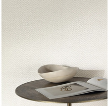 Close-up van een behang met visgraatmotief, gecombineerd met een schaal en een tijdschrift op een bijzettafel