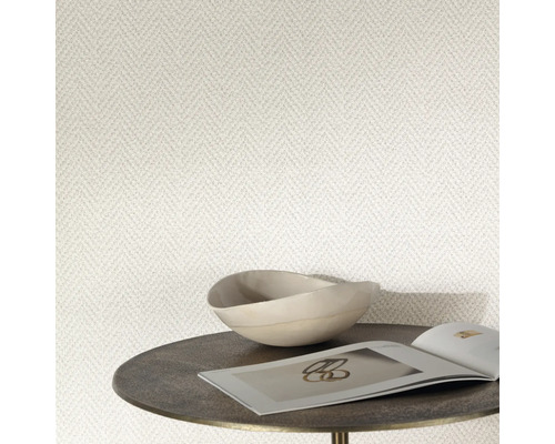 Close-up van een behang met visgraatmotief, gecombineerd met een schaal en een tijdschrift op een bijzettafel