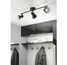 Zwarte plafondlamp met drie spots in een modern ingerichte hal.