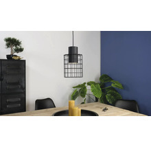 Scene met een hanglamp met een kooischerm boven een houten tafel