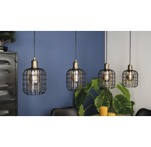 Vier hanglampen met kooischermdesign hangen boven een eettafel