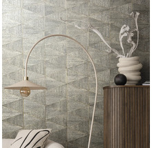 Wanddecoratie met driehoekige tegels, staande lamp en commode in de kamer.