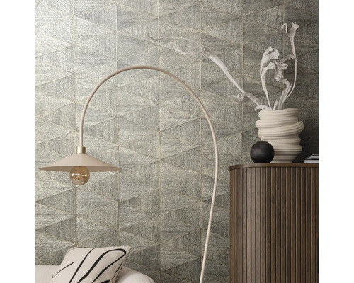 Wanddecoratie met driehoekige tegels, staande lamp en commode in de kamer.