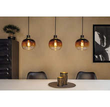 Scene met drie glazen hanglampen boven een eettafel