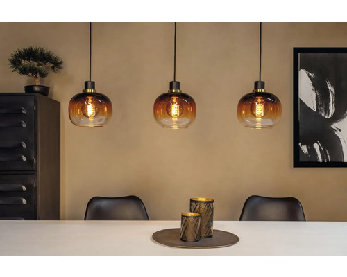 Scene met drie glazen hanglampen boven een eettafel