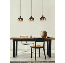 Eettafel met drie hanglampen, stoelen en decoratie