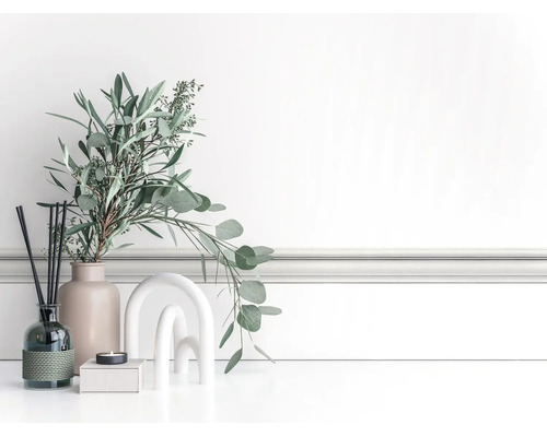 Lichte, georganiseerde decoratieve scène met eucalyptustakken in een keramieken vaas, geurstokjes, een kaars en een boogsculptuur voor sierlijsten.