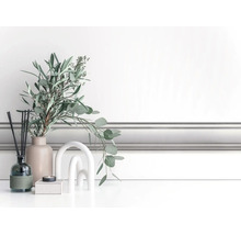 Klassieke witte wandlijst, gemonteerd als lambrisering in een lichte kamer met moderne decoratie.