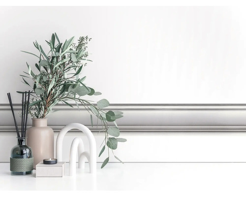 Klassieke witte wandlijst, gemonteerd als lambrisering in een lichte kamer met moderne decoratie.