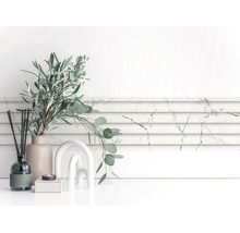 Wandpaneel in marmerlook wit-grijs, horizontaal geplaatst, in een lichte, modern ingerichte kamer met decoratie.