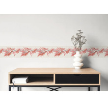 Behangrand met bamboepatroon boven een houten dressoir met vaas.