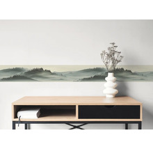 Zelfklevende wandborder met boslandschap en misteffect boven een dressoir.