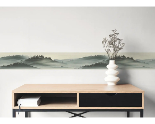 Zelfklevende wandborder met boslandschap en misteffect boven een dressoir.