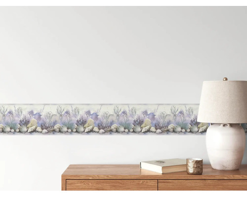 Behangrand met maritieme motieven zoals schelpen en koralen in aquarel-look op een lichte muur boven een houten dressoir.