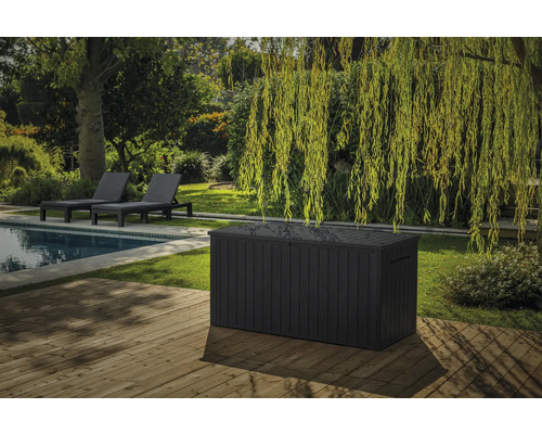 Tuinscene met zwembad, ligstoelen en een ruime kunststof opbergbox op een houten terras