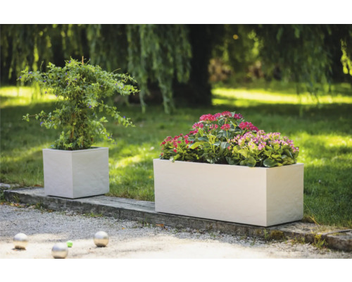 Twee beplante, kubusvormige plantenbakken in de tuin