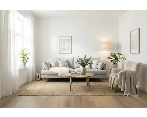 Woonkamer met bank, fauteuil, vloerkleed en tafel in licht design.