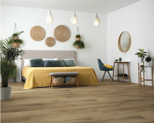 Slaapkamer met bed, bank, stoel, planten en houten vloer