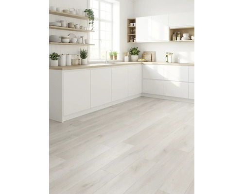 Lichte keuken met witte kasten, houten werkblad en lichte houten vloer.