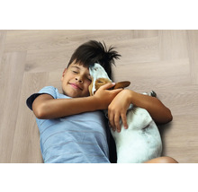 Jongen knuffelt hond op houten vloer