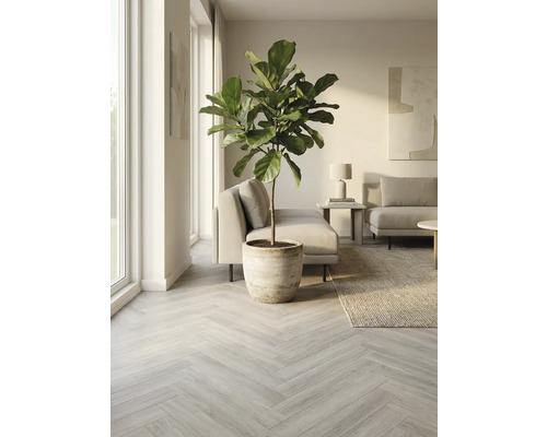 Lichte woonkamer met lichtgrijze visgraat parketvloer, potplant, bank, tapijt en kunst