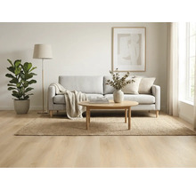 Woonkamer met bank, vloerkleed, tafel, staande lamp en kamerplant