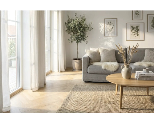 Woonkamer met bank, tafel, vloerkleed, kamerplant en decoratie