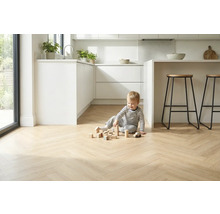 Lichte visgraatparketvloer in een moderne keuken met spelend kind