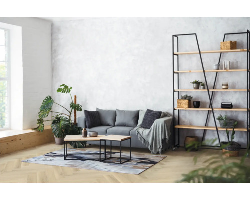 Lichte woonkamer met bank, planken en kamerplanten.