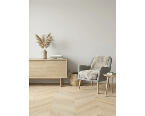 Lichte woonkamer met houten vloer, dressoir, fauteuil en decoratie