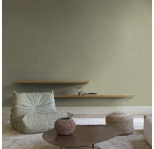 Woonkamer met fauteuil, planken en salontafel op een vloerkleed