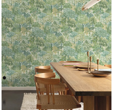 Een eetkamer met een houten tafel en stoelen tegen een behang met een boommotief.