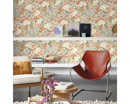 Woonkamer met bloemenbehang, planken, fauteuils en decoraties voor een huiselijke sfeer